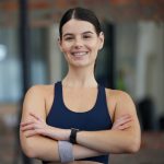 Woman in gym, portrait and exercise with smile for fitness, health and cardio with active lifestyle